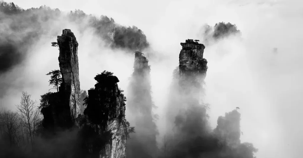 Zhangjiajie en couple : voir l’“Avatar” sans se cramer (et avec un timing réaliste) Dramatic black and white image of Zhangjiajie peaks enveloped in mist.