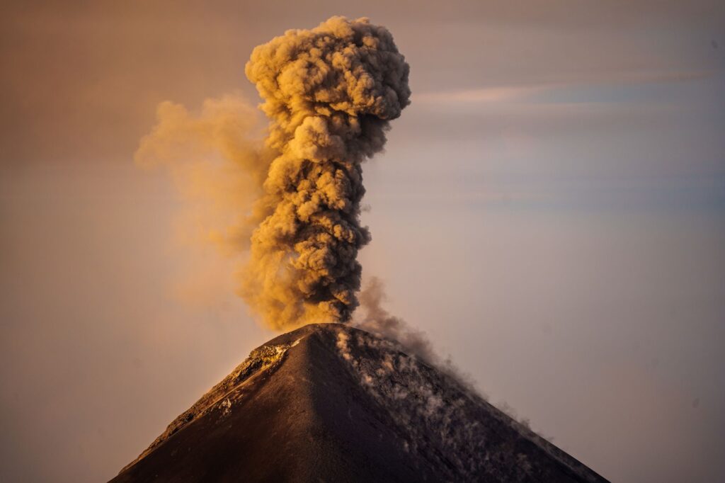 Dramatic sunrise view of Acatenango Volcano erupting with smoke plume in Guatemala.