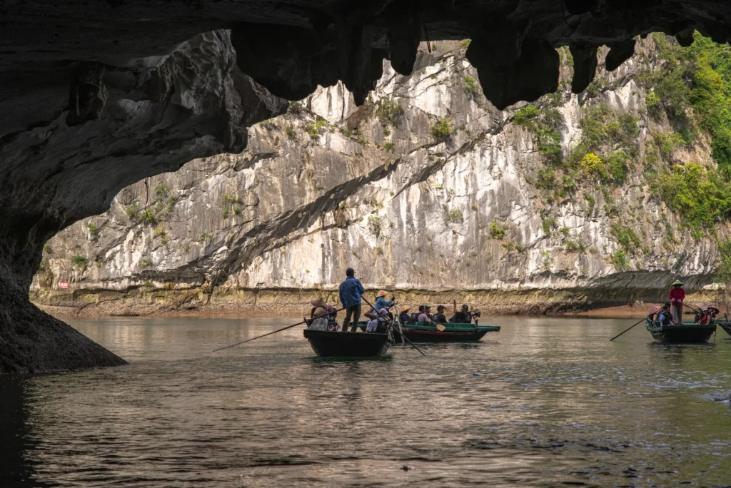 Explore picturesque limestone caves and cliffs in Vietnam with a traditional boat tour, surrounded by natural beauty.