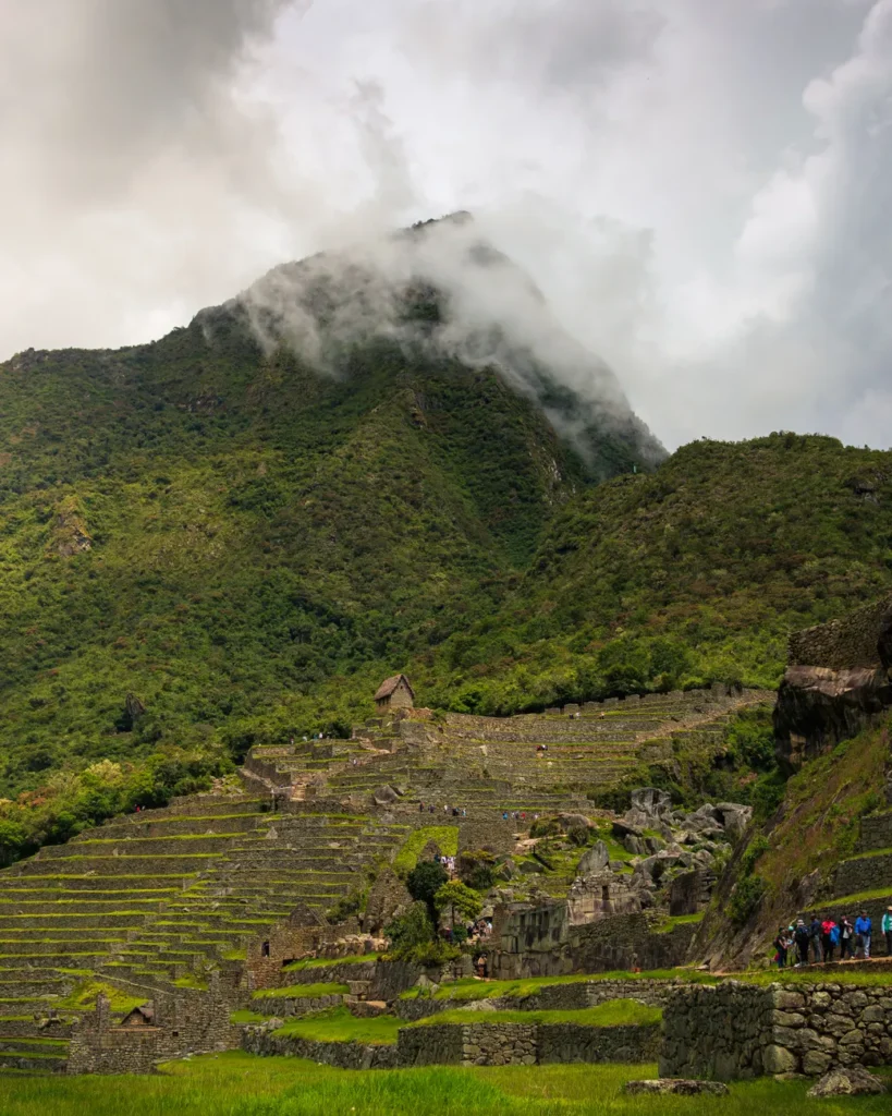 Explore the ancient Inca citadel of Machu Picchu surrounded by lush Andes Mountains under a mystical cloud cover.