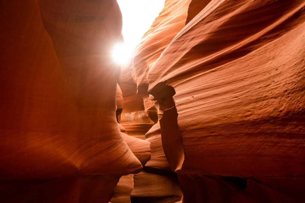 Explore the mesmerizing red rock formations of Antelope Canyon with sunlight peeking through.