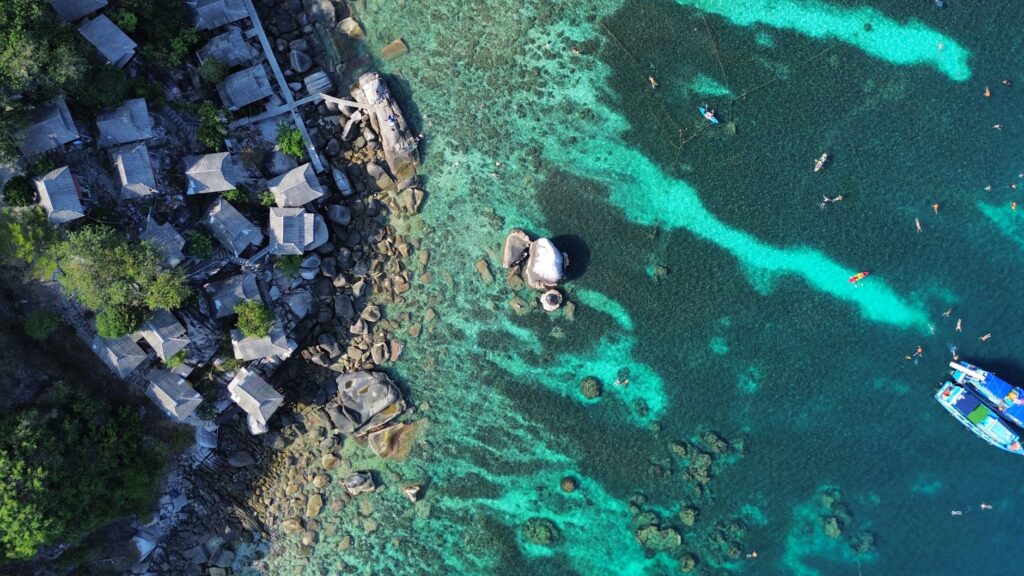 Explore the stunning coastline and clear waters of Ko Tao, Thailand from above.