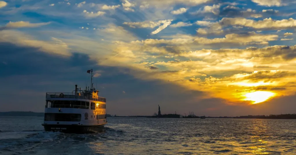 New York à deux : quoi réserver en avance pour éviter les galères (et gagner du temps) Ferry cruise at sunset with the Statue of Liberty in New York Harbor.