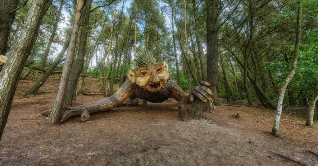 Intriguing wooden troll sculpture in Vesterbjerge, Denmark forest setting.