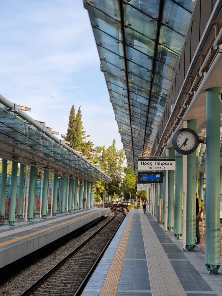 Modern Athens train station with glass roof and clock, capturing the essence of Greek transit.