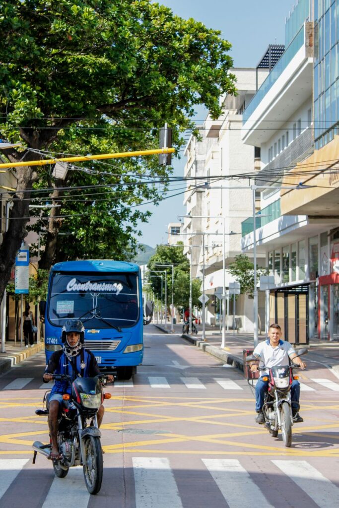 Motorcyclists and a bus on a busy street in Santa Marta, Colombia.