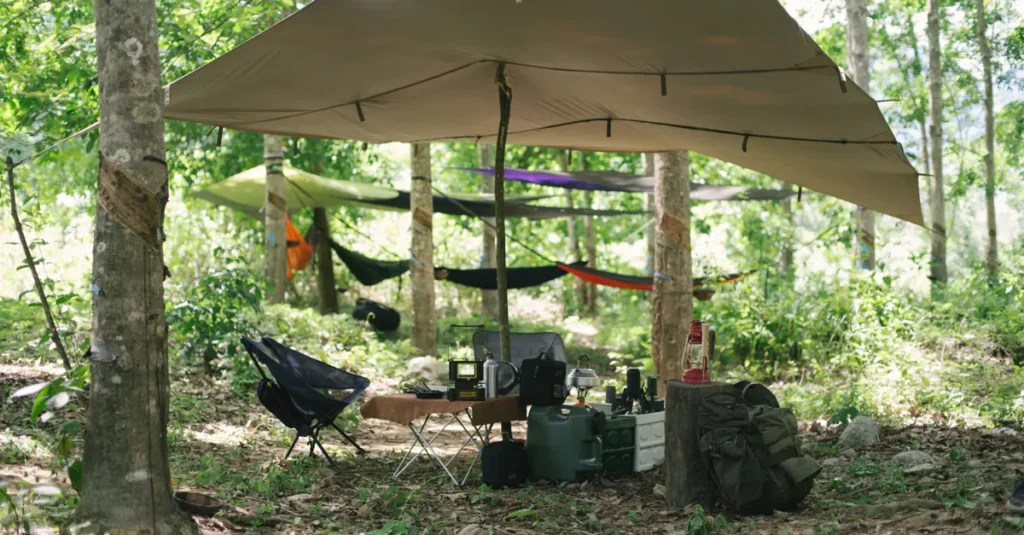 Kasikasima en couple au Suriname : l’expédition jungle qui fait vraiment le job (sans marathon inutile) Outdoor camping setup with equipment and hammocks under tree canopy in the forest.