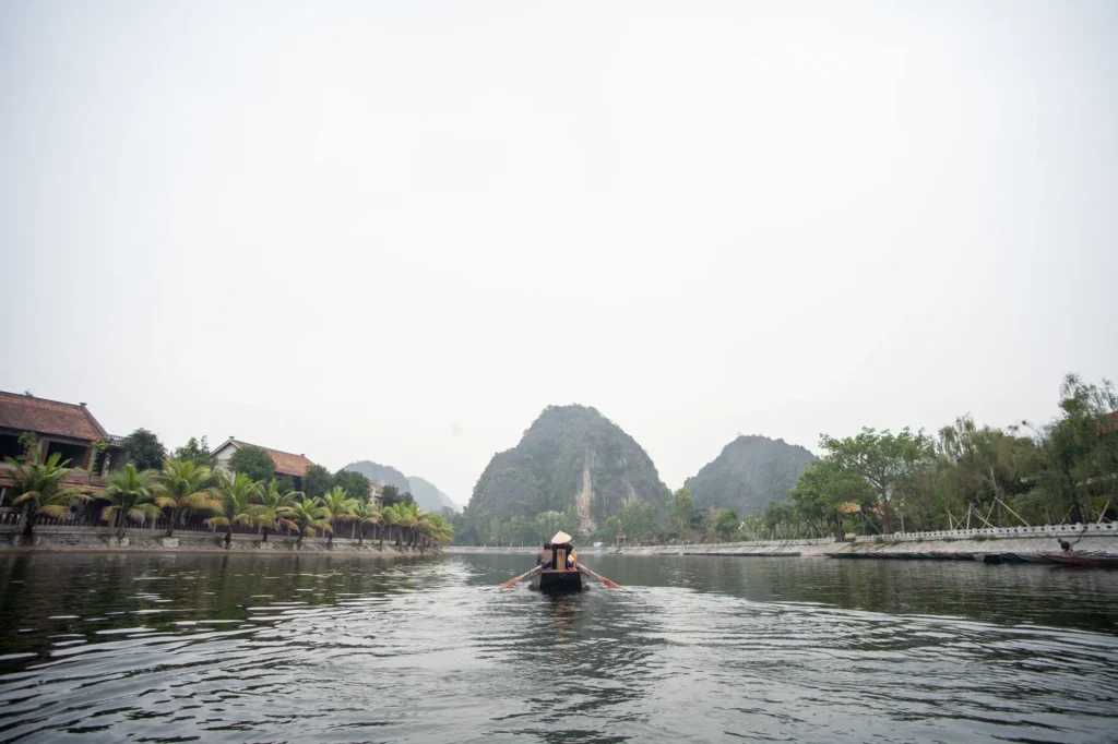 Peaceful boat ride on a river with limestone karsts in Ninh Bình, Vietnam.