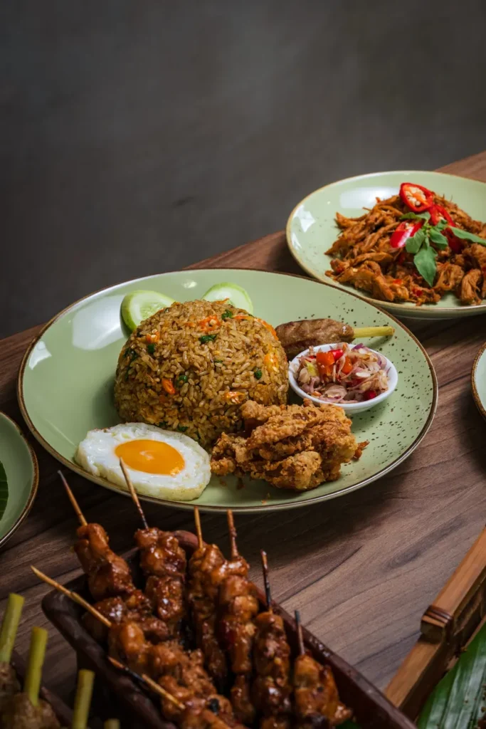 Plate of Nasi Goreng with fried egg and satay, showcasing traditional Indonesian flavors.