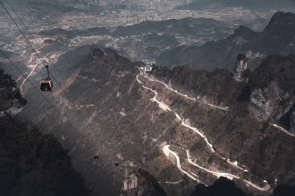 Scenic aerial view of Tianmen Mountain with cable car and winding road in China.