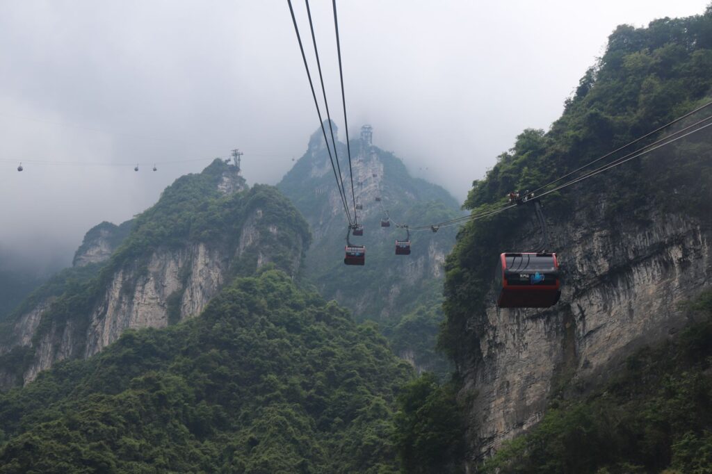 Scenic view of cable cars ascending Tianmen Mountain in Zhangjiajie, China, shrouded in mist.