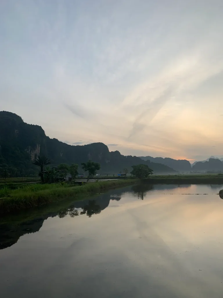 Serene landscape of Minasatene, Indonesia, with rice paddies and mountains at sunrise.