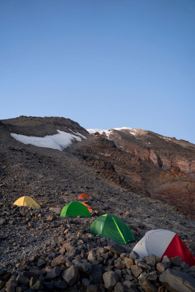Serene mountain camping scene with tents and rocky landscape in Karagüney, Turkey.