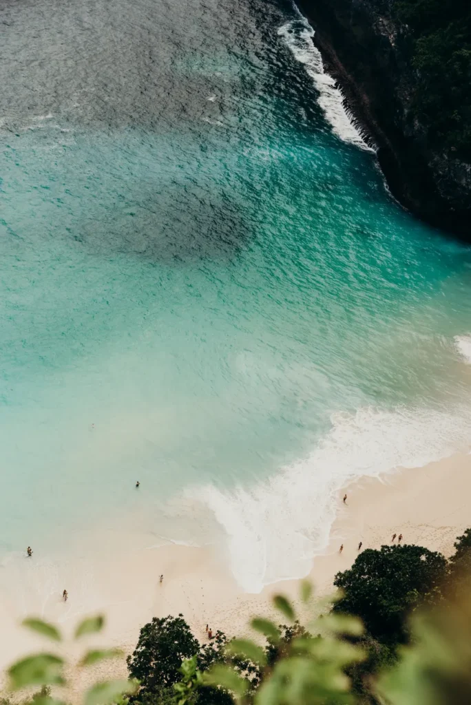 Stunning aerial shot of a tropical beach in Bali with turquoise waters and white sand.