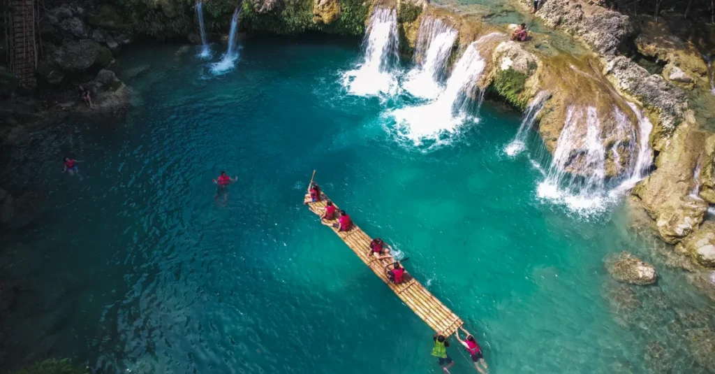 Suwat Waterfall à Bali : le guide concret à deux pour une baignade “hidden gem” près d’Ubud Stunning aerial shot of tourists rafting in the turquoise waters of Bolinao's blue lagoon with waterfalls.