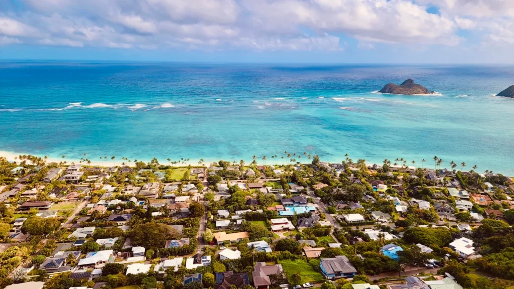 Stunning aerial view of a coastal town with lush greenery and a turquoise ocean.