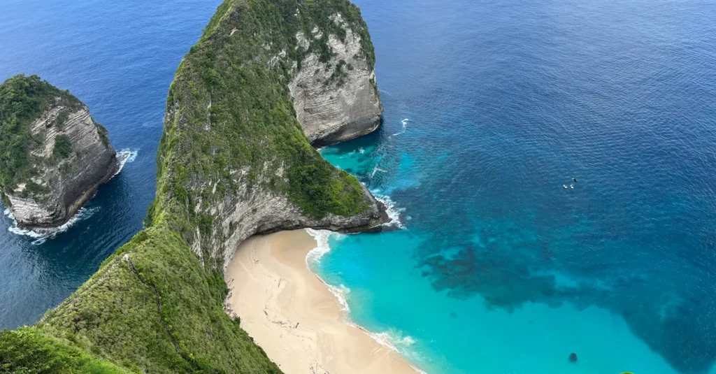 Puyung Beach à Nusa Penida à deux : le secret blanc, le chemin dans les arbres et le plan sans galère Stunning aerial view of Kelingking Beach with turquoise waters and white sandy beach on Nusa Penida, Indonesia.