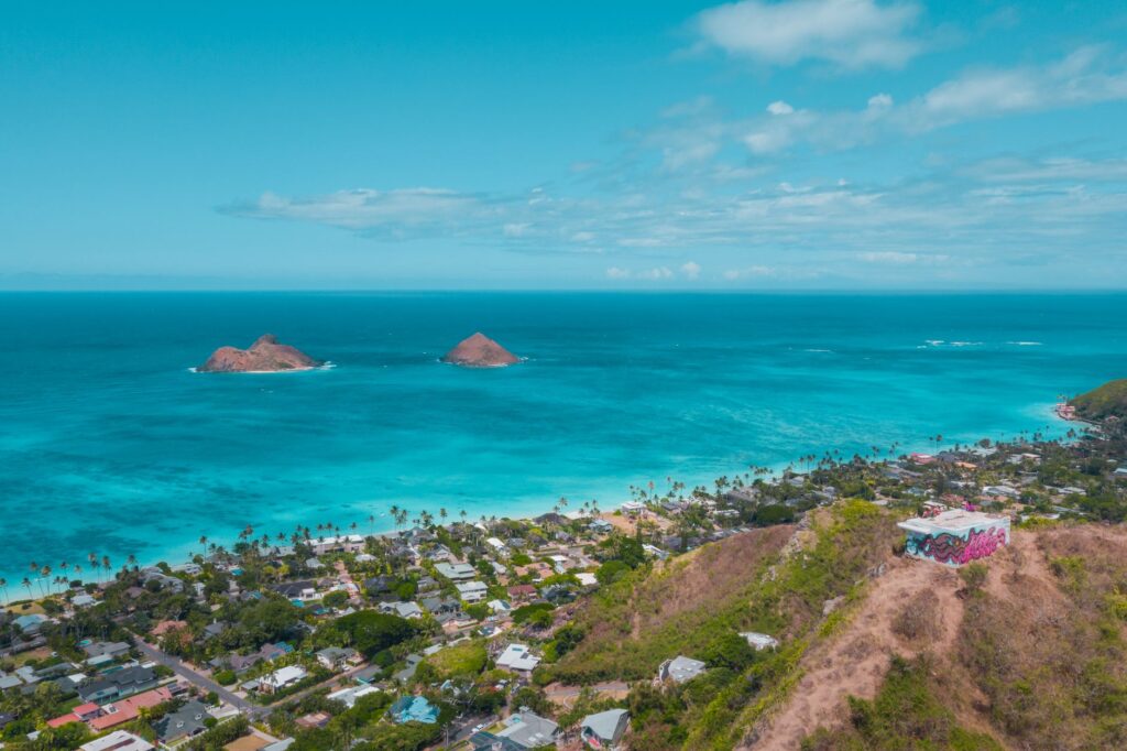 Stunning aerial view of Lanikai Beach and Mokulua Islands in Hawaii, showcasing vibrant blue waters and coastal scenery.