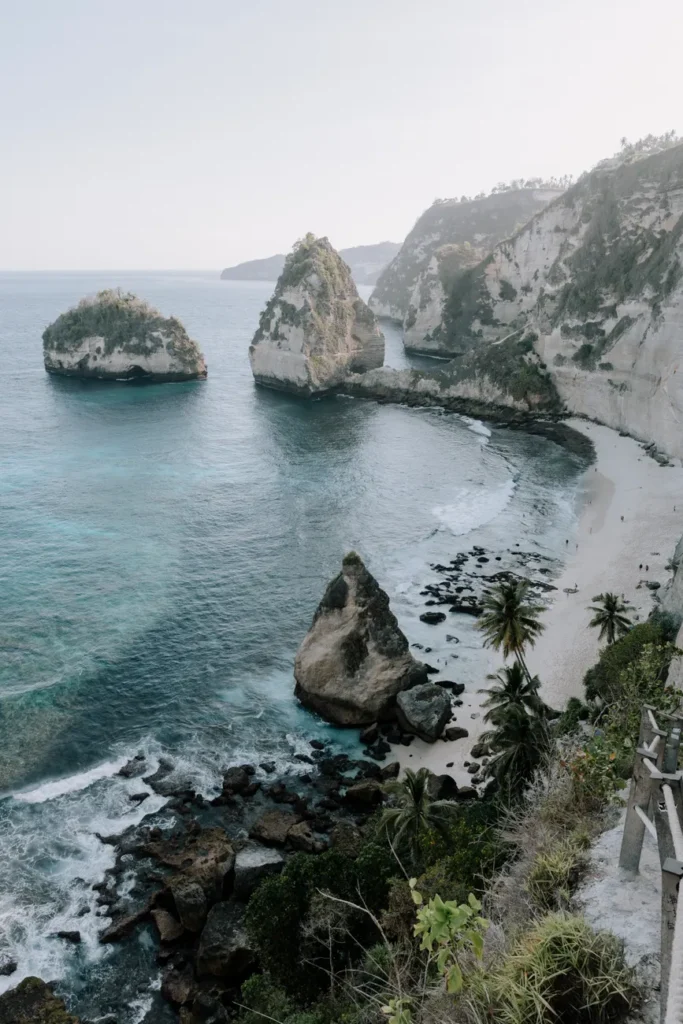Stunning aerial view of rocky coastline and blue waters at a beach in Bali, perfect for travel inspiration.