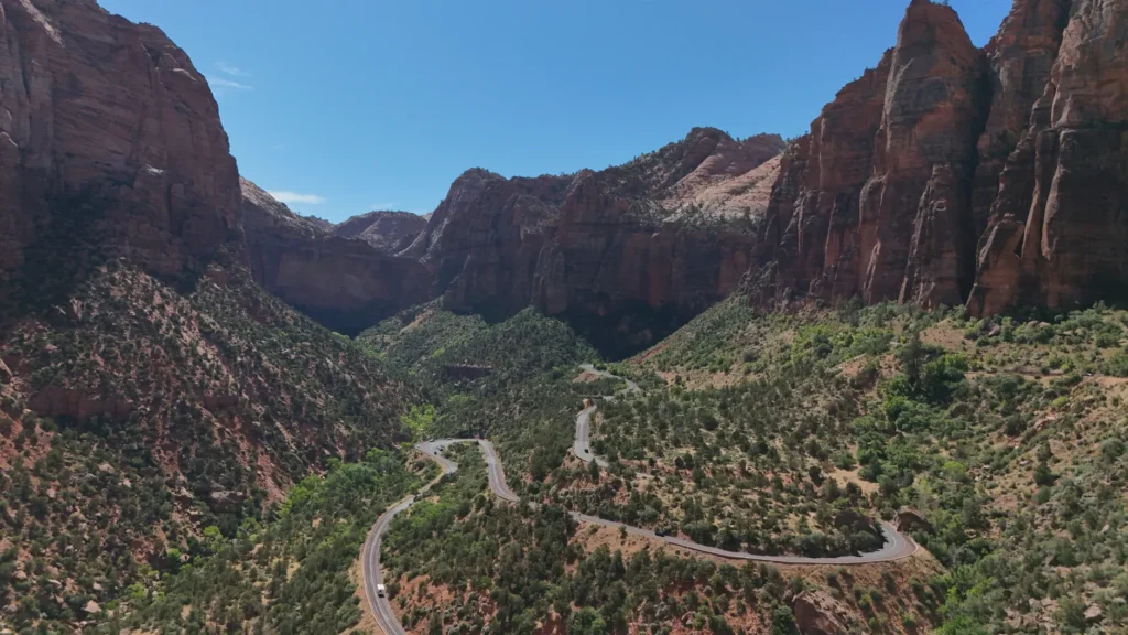 Stunning aerial view of winding road through Zion National Park's red rock formations in Utah.