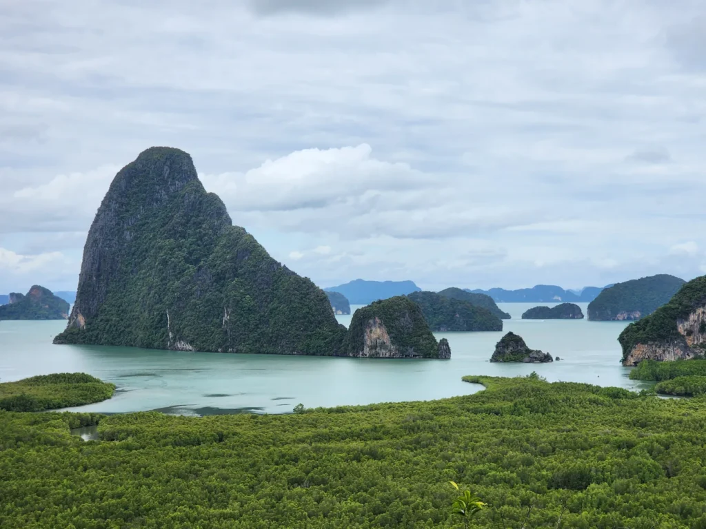 Stunning daytime view of Phang Nga Bay's limestone formations and lush greenery in Thailand.