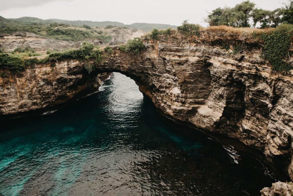 Stunning natural arch formation over turquoise ocean waters in Bali, Indonesia.