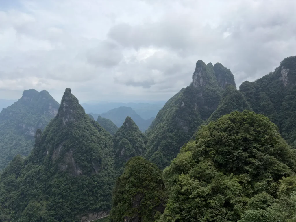 Stunning view of mountainous peaks in Zhangjiajie National Forest Park, China, covered with lush greenery.