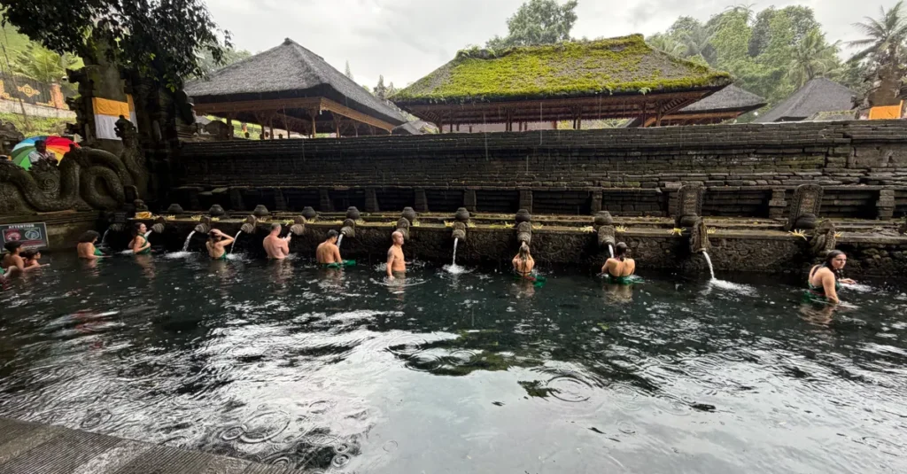 Temples d’Ubud en couple : le guide concret pour voir du sacré… sans vous faire aspirer par la foule Tourists enjoy a traditional holy bathing ritual at Tirta Empul Temple, Bali.