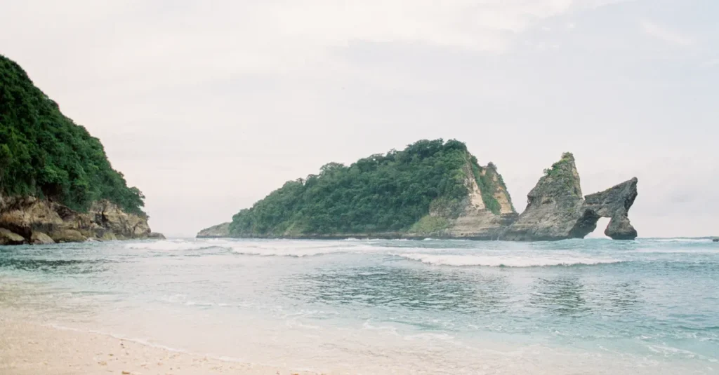 Atuh Beach à Nusa Penida en couple : le guide concret “détente, rocher stiletto & plan sans stress” Tranquil beach scene with natural rock formations at Nusa Penida, Bali.