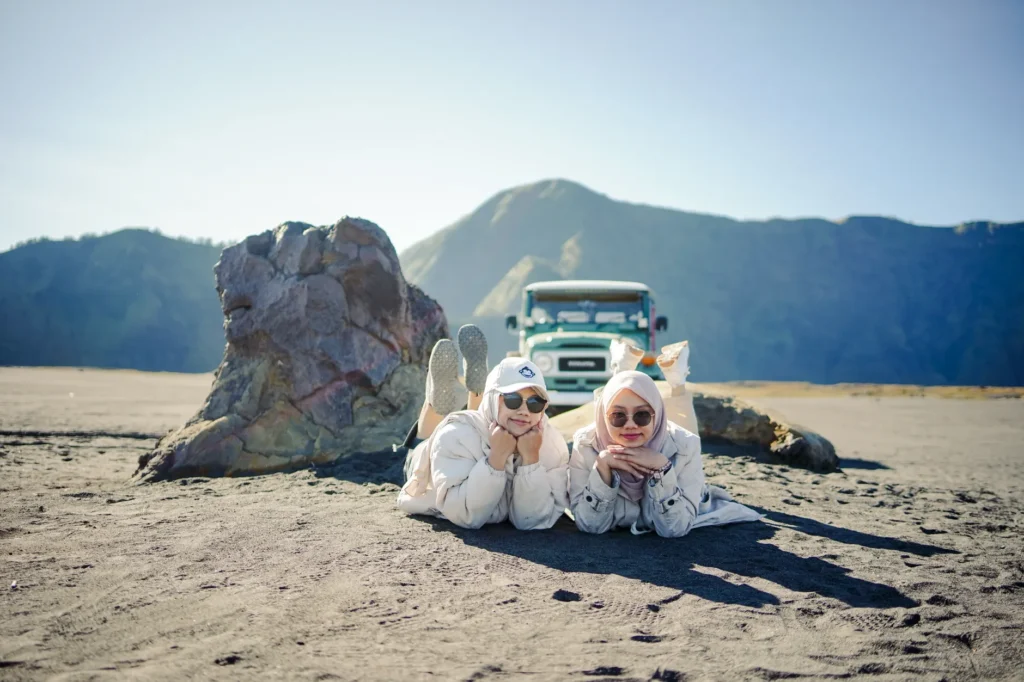 Two friends enjoy a relaxing day in the sandy plains of Mount Bromo, East Java.