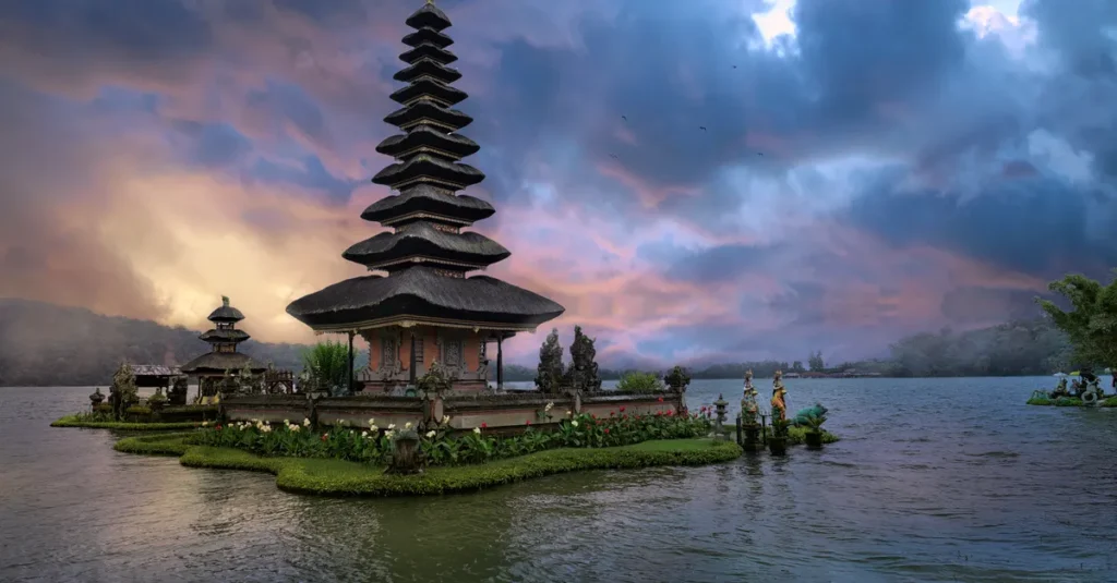 Bali en couple : le guide concret pour profiter (vraiment) sans vous faire aspirer par la foule Ulun Danu Bratan Temple in Bali, Indonesia, beautifully reflected on the lake at twilight.