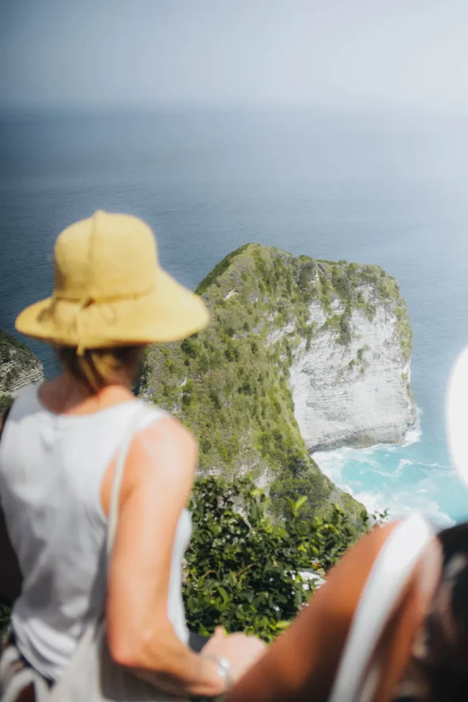 Woman admiring the dramatic cliff views of Nusa Penida, Indonesia. A breathtaking travel destination.