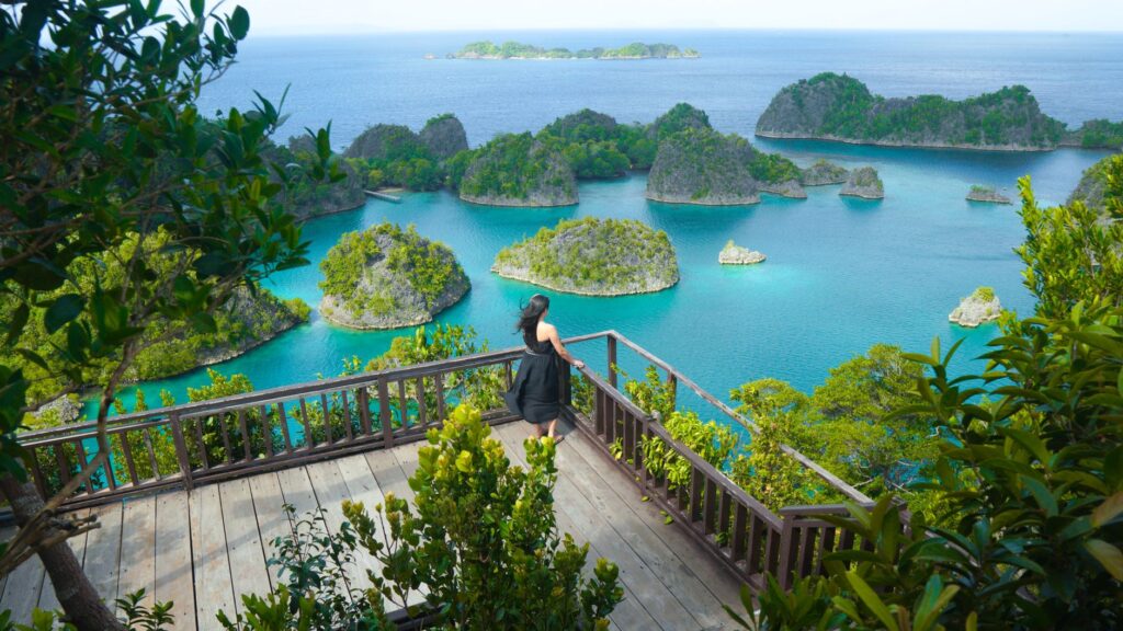 Woman enjoying scenic view of Piaynemo Islands in Raja Ampat, Indonesia.