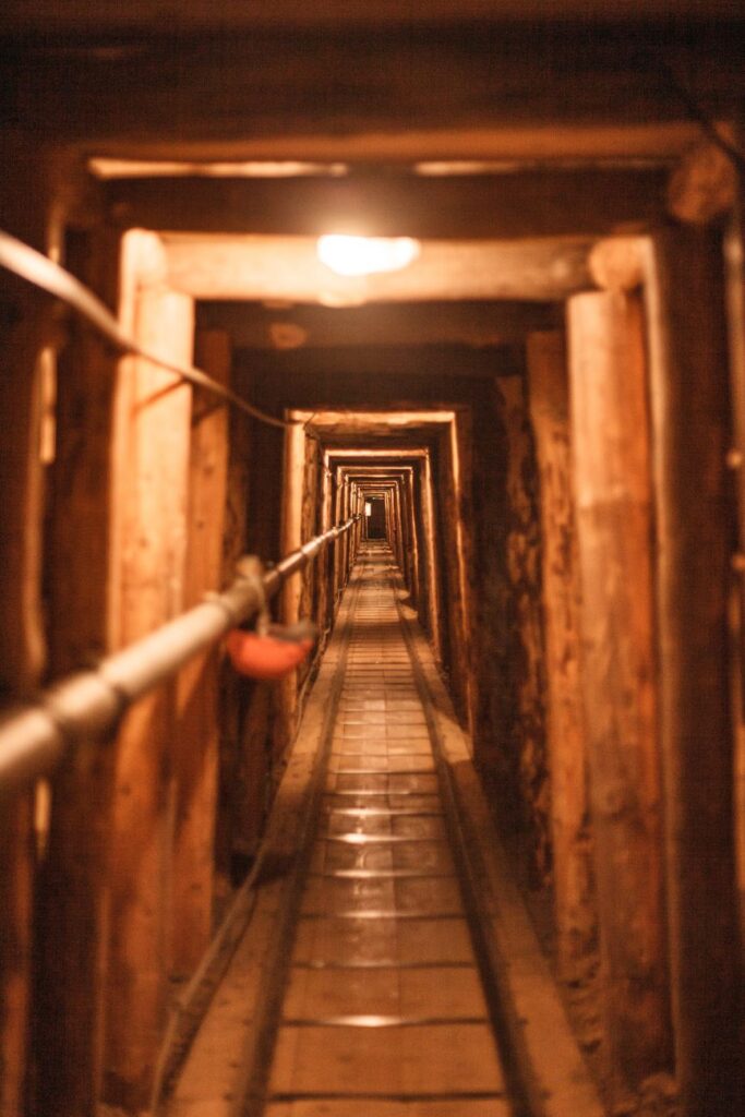 A long, dimly lit tunnel with wooden supports, showcasing depth and perspective.